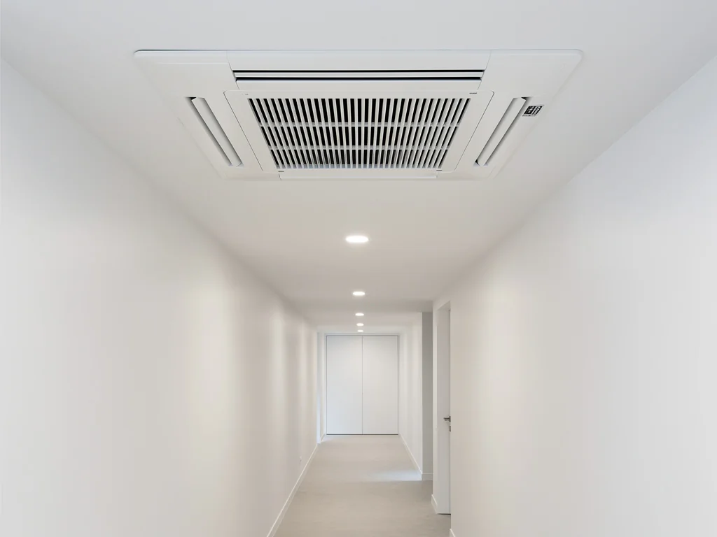 Cassette de climatisation intégrée au plafond d'un couloir aux murs blancs
